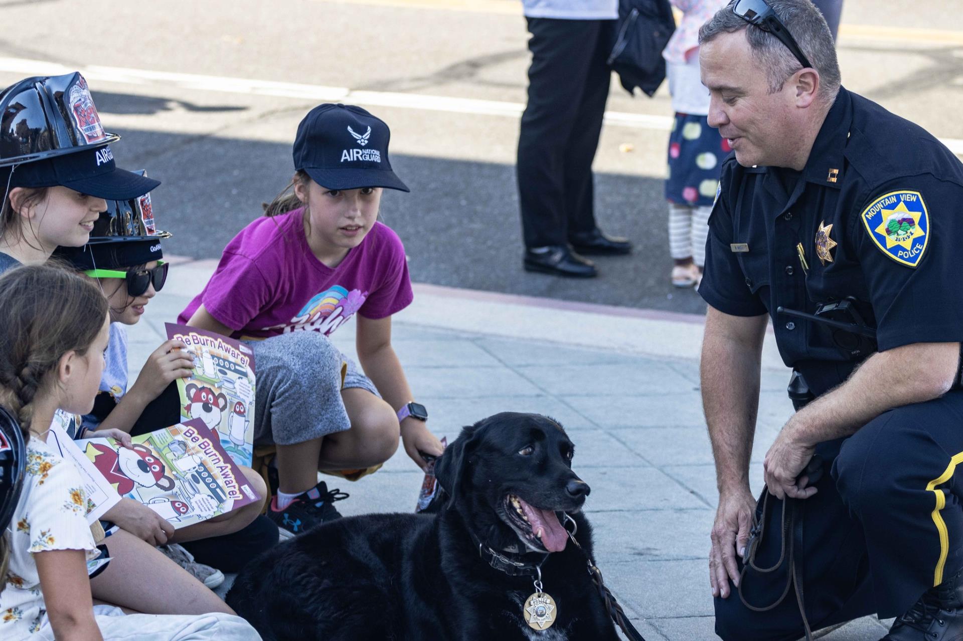 Children petting police officer's service dog